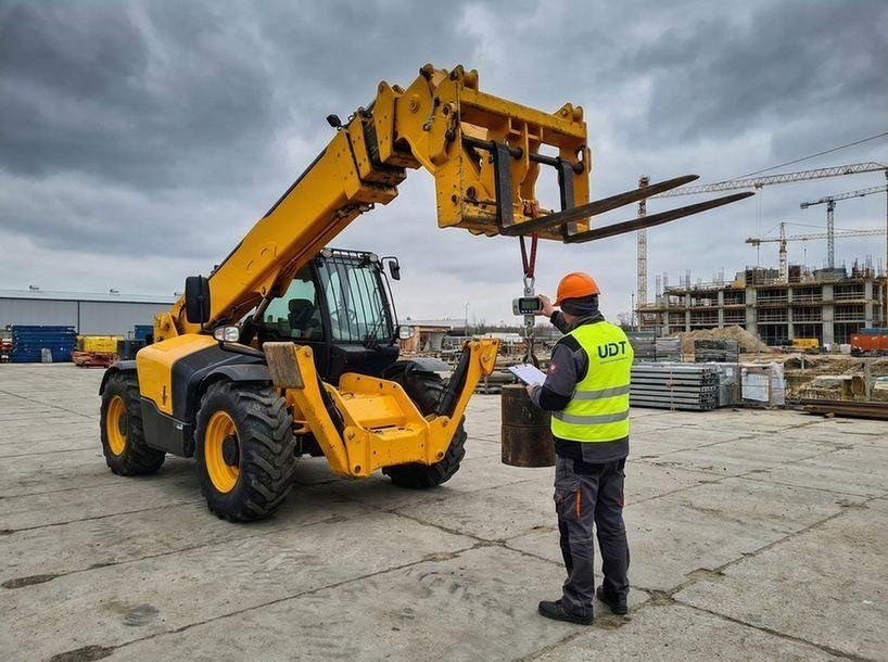 Technik przeprowadzający badania techniczne urządzenia dźwigowego dla UDT